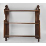 An early 20th century mahogany wall shelf comprising three shelves on pierced uprights, 66.5 x 61cm.