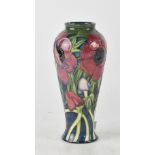 Moorcroft; a slender tube lined 'Anemone' pattern baluster vase, green and midnight blue ground,