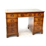A Georgian-style leather inset mahogany nine-drawer kneehole twin pedestal desk, on bracket feet,