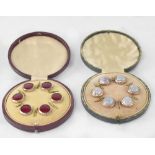 Two cased sets of six gilt buttons, one with red guilloché enamelled centres,