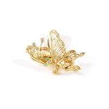 An 18ct yellow gold butterfly brooch set with small diamonds, green stone eyes, and moveable wing,