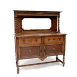 An early 20th century oak mirror back sideboard with carved upper frieze above bevelled mirror