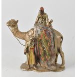 A Bergman-style cold painted spelter figure depicting a carpet seller on a camel, unsigned,