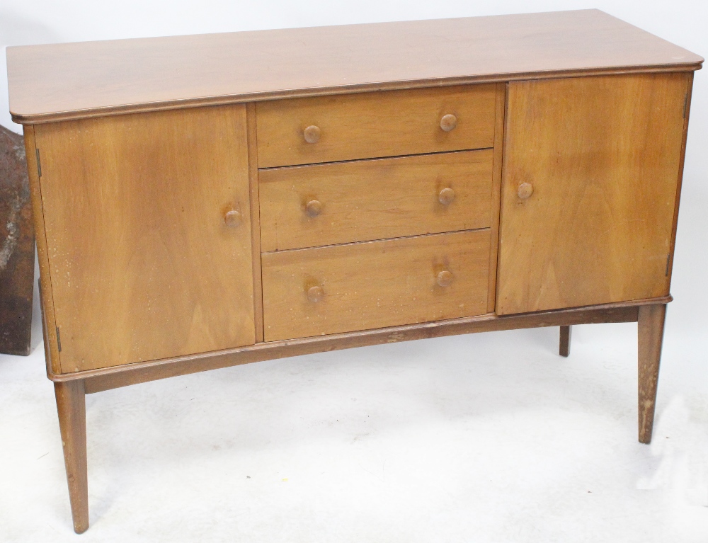A 1950s walnut sideboard with three central drawers flanked by cupboard doors,