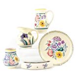 Five pieces of Poole pottery all decorated with flowers within dotted borders,