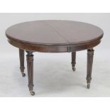 An early 20th century mahogany wind out table, with two additional leaves,