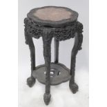 A late 19th century Chinese carved hardwood urn stand with pink marble insert top,