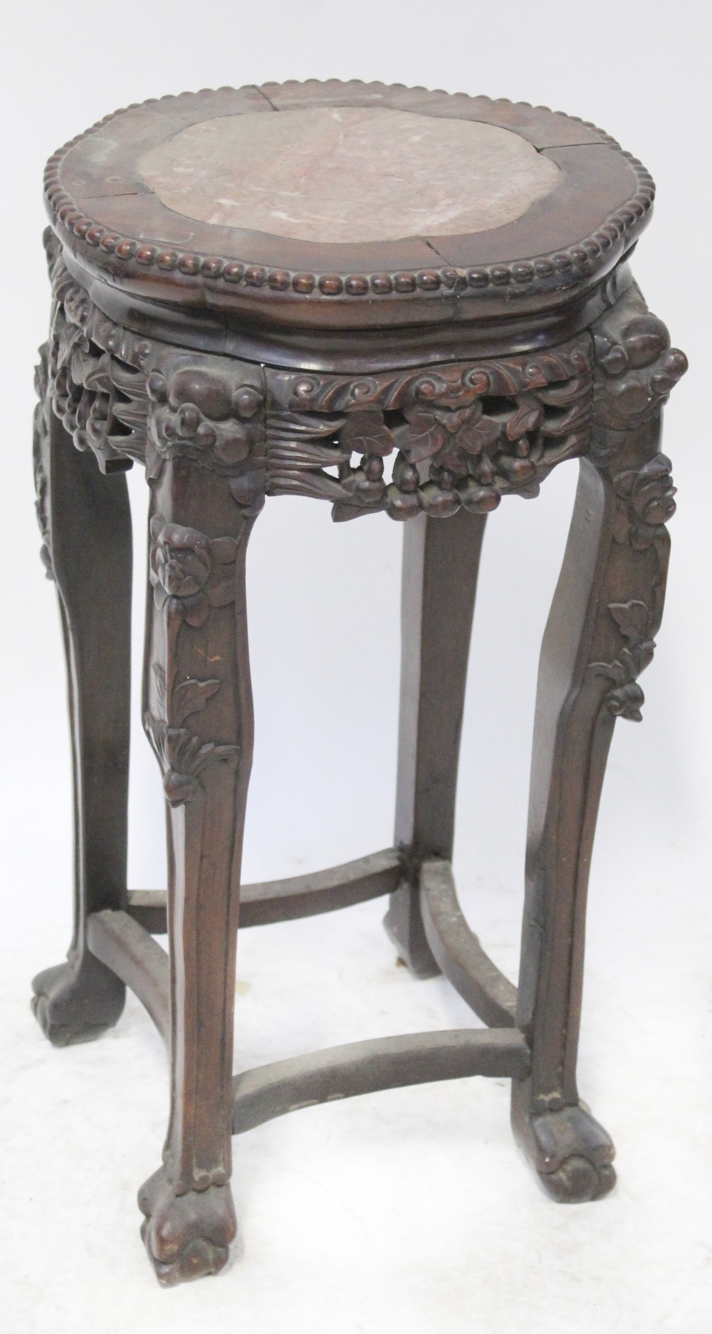 A late 19th century Chinese hardwood small urn stand with pink marble insert top,