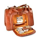 An Argentinian brown leather vanity travelling bag with metal mounts and clasp,