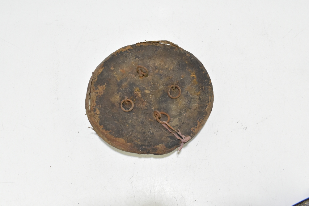 An Indian hide covered dahl shield with applied brass devices, for restoration, diameter 26.5cm. - Image 2 of 2