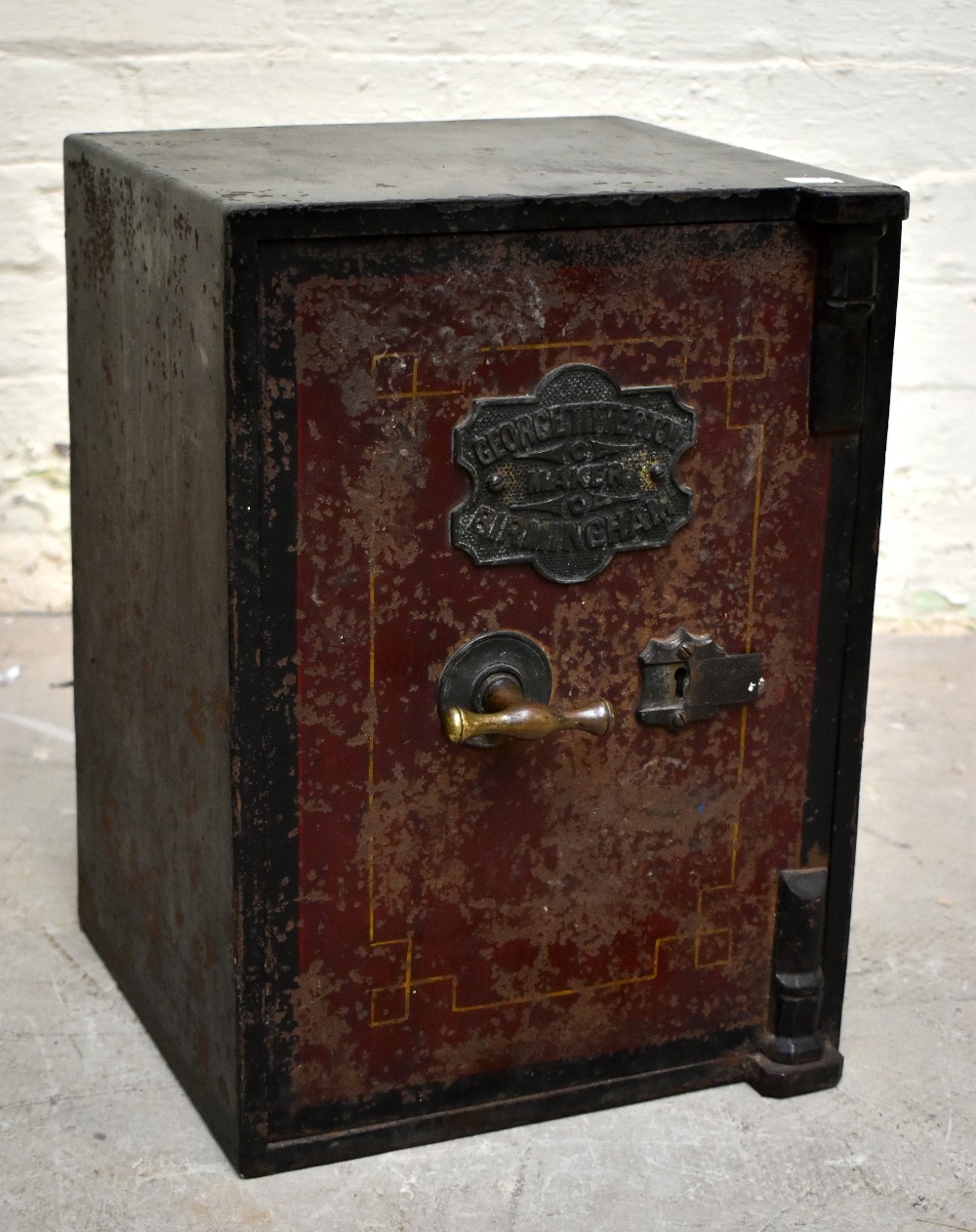 A cast iron safe of small proportions, with label for George Titterton Maker Birmingham, with door