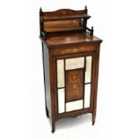 An Edwardian inlaid rosewood music cabinet with raised back above a panelled door and inset with six