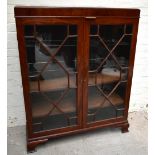 An early 20th century mahogany bookcase, the pair of astragal glazed doors, enclosing an arrangement
