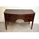 An early 19th century mahogany bowfront sideboard with boxwood stringing, with an arrangement of