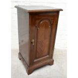 An early 20th century mahogany pot cupboard, with single panelled door enclosing fixed shelf, raised