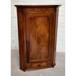 A Georgian flat fronted mahogany corner cupboard with a single panelled door above single drawer,