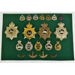 EAST LANCASHIRE REGIMENT; a good group of badges including four helmet/shako plates, one gilt with