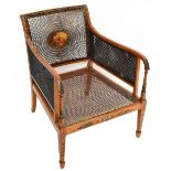 An Edwardian satinwood and painted bergère caned tub chair with single caned back centred with an