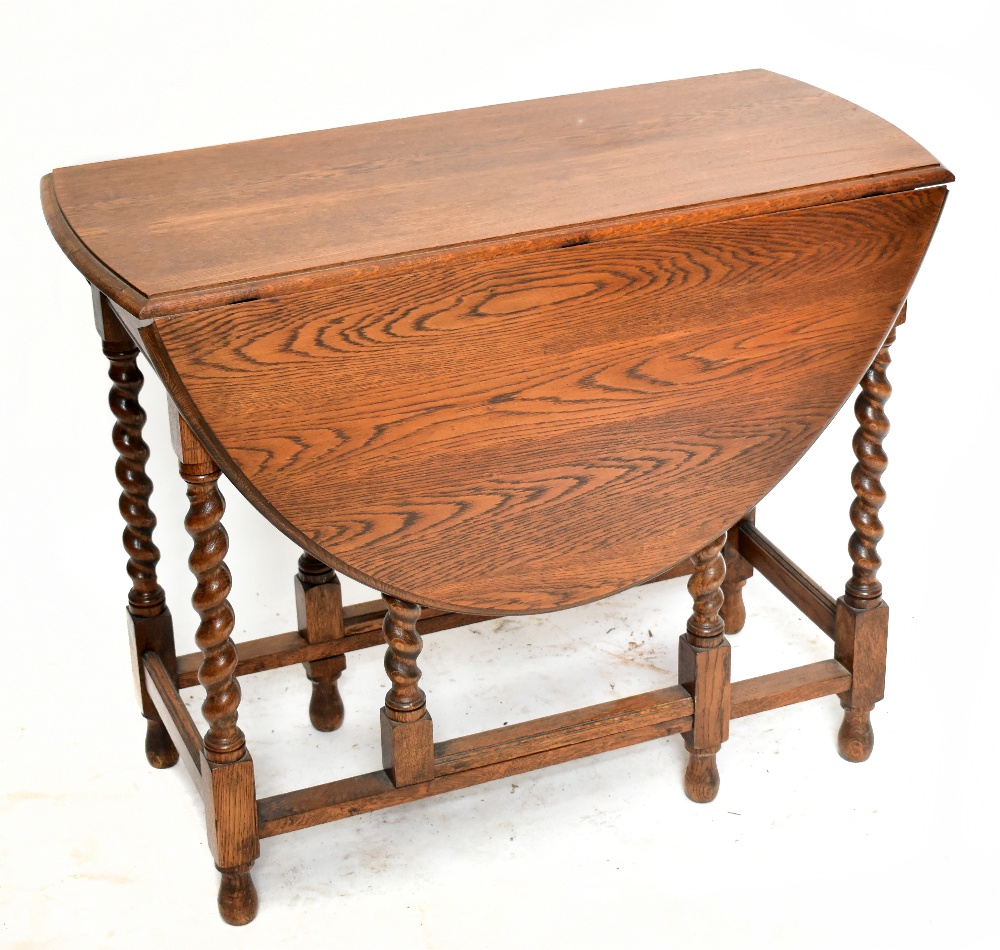 A 1920s oak dropleaf gateleg dining table, raised on barleytwist supports, height 73cm, length 88cm.