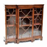 A late 19th century breakfront bookcase, the three astragal glazed doors enclosing adjustable