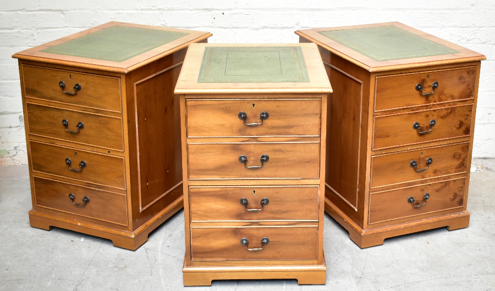 Three reproduction yew wood filing cabinets, each with a green leather inset top above two filing