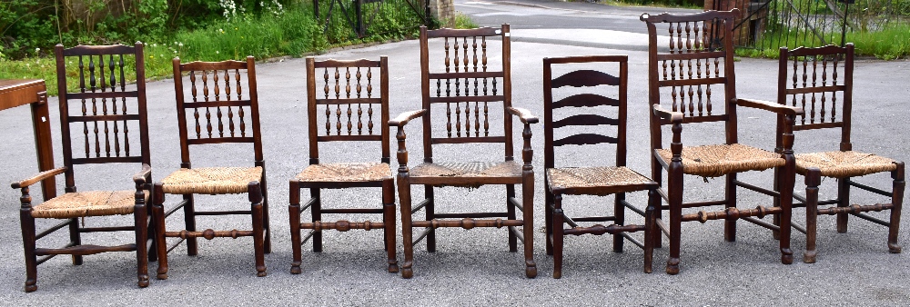 Seven 19th and 20th century rush seated spindle and ladder back chairs, each raised on turned column