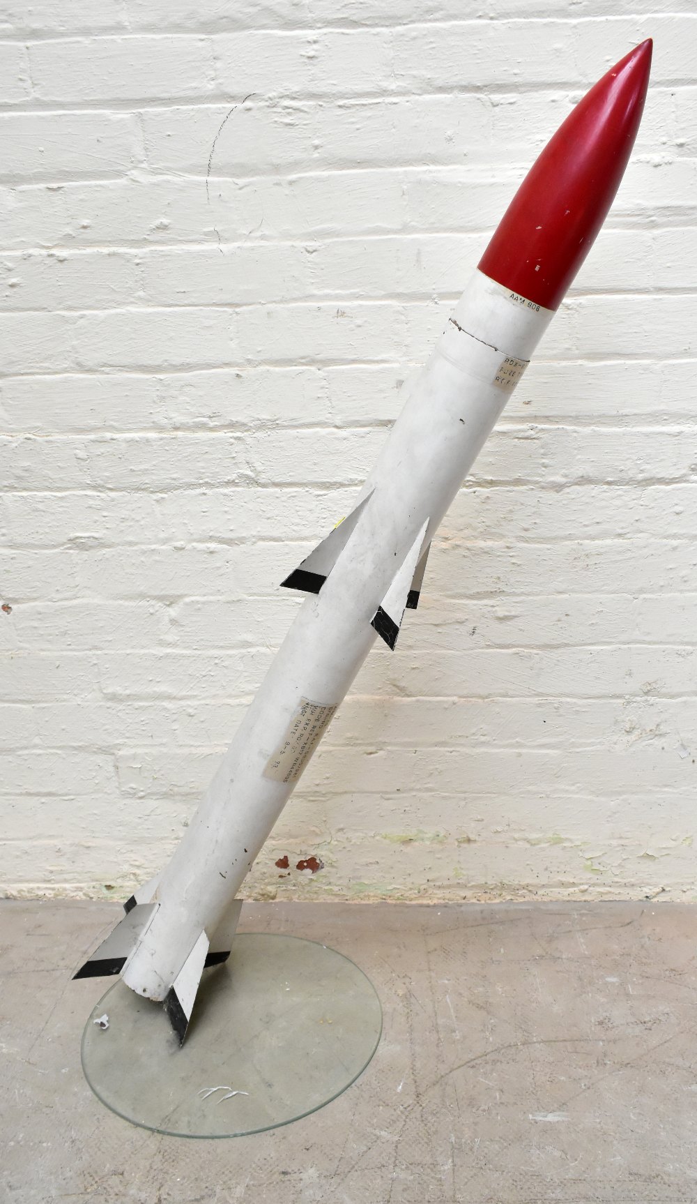 A painted metal model rocket/missile bearing various labels, length 136cm, with stand. Provenance: