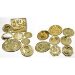 A collection of thirteen early 20th century embossed brass wall plates and chargers, probably Dutch,