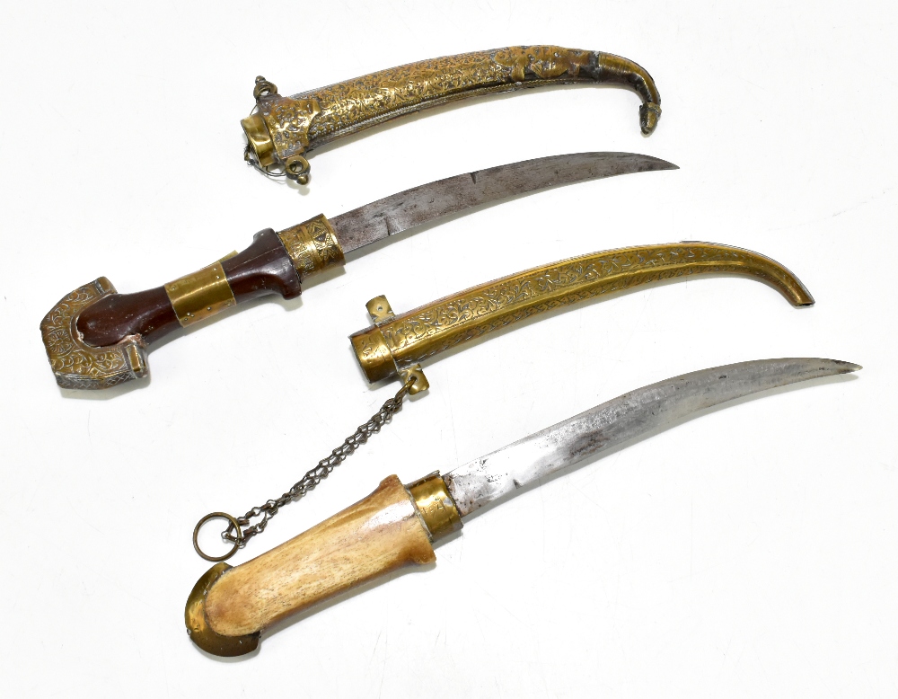 Two North East African/Middle Eastern jambiyas of typical form, both with brass scabbards, length of