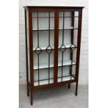 An Edwardian inlaid mahogany display cabinet, with two astragal glazed doors enclosing glass