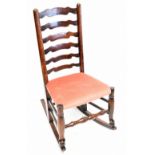 A 19th century oak framed ladder back rocking chair, with later upholstered cushion seat.