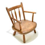 A child’s elm seated open sided armchair, raised on column supports, height 40cm.