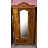 An Edwardian inlaid mahogany wardrobe, with single mirrored door above a base drawer, on bracket