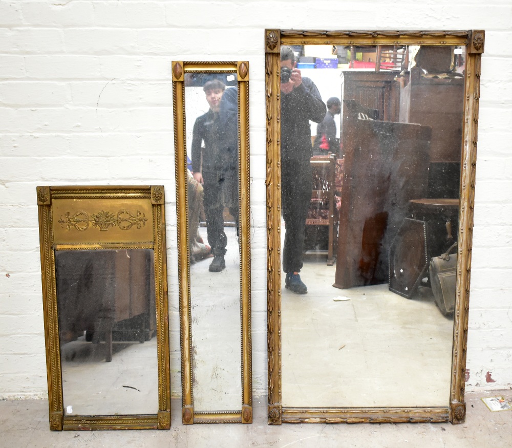 A 19th century gilt wood wall mirror of rectangular form, with boarded back, 141 x 73cm, together