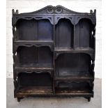 A 19th century carved oak wall cupboard, with an arrangement of seven sections with carved side