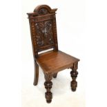 A substantial Victorian carved oak hall chair, the back decorated with a lion's head mask and