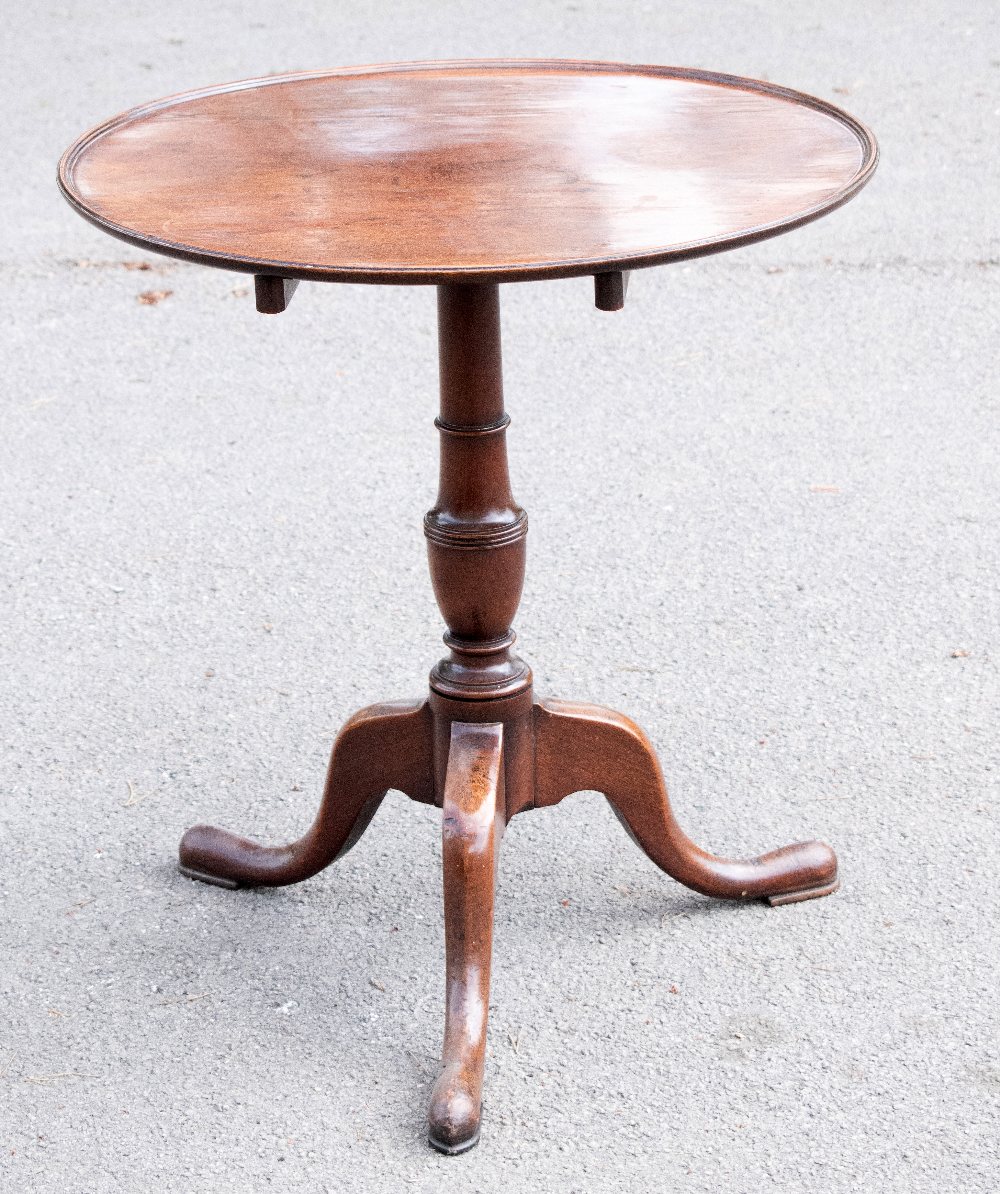 An early 19th century mahogany circular tilt top occasional table, the dished top with a moulded