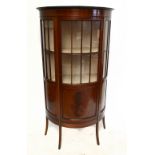 An Edwardian mahogany and boxwood inlaid bowfront display cabinet, with curved door enclosing two