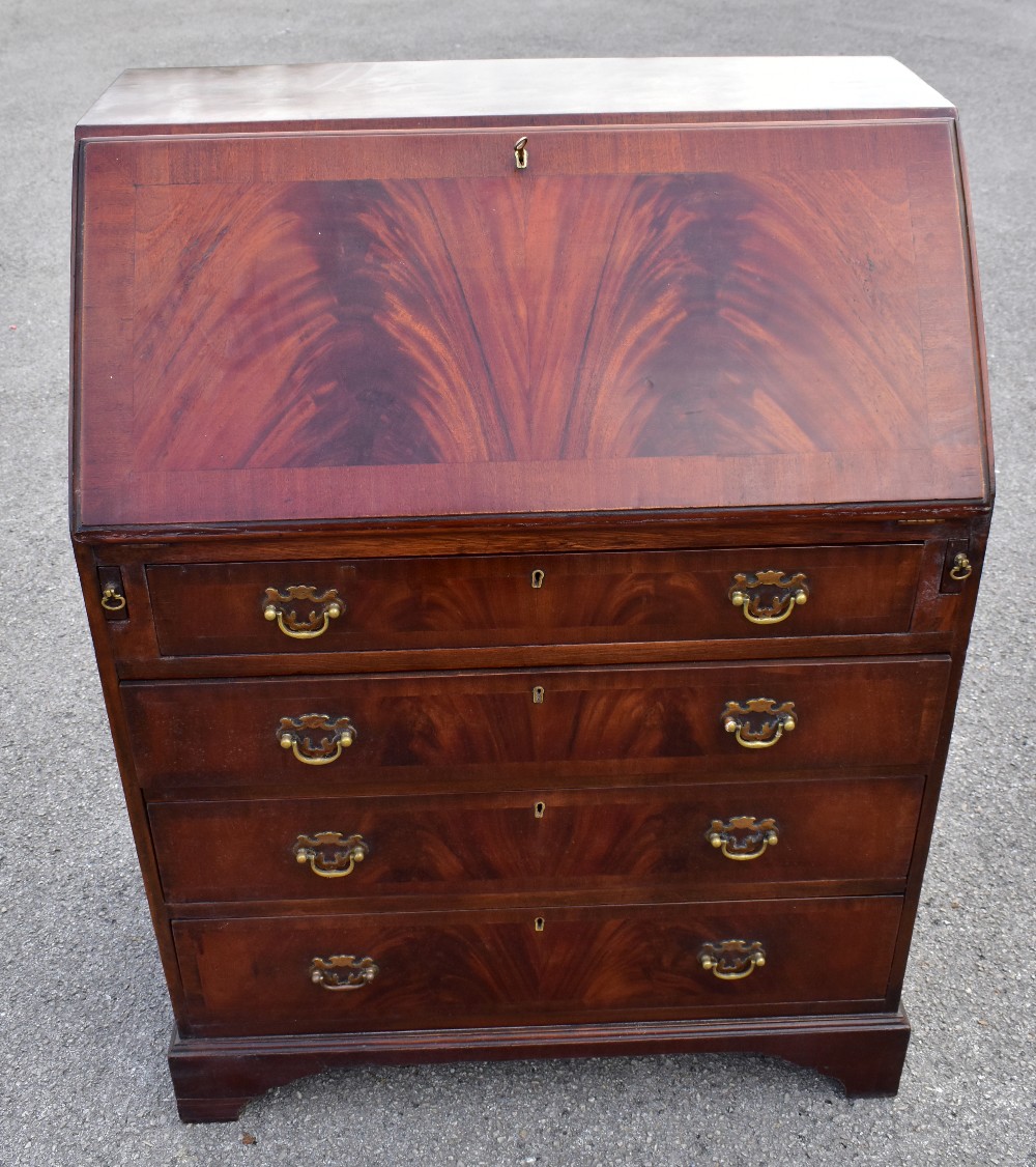 A reproduction mahogany veneered bureau, the fall front above four drawers, raised on bracket