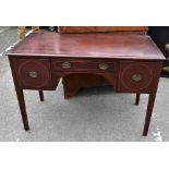 An Edwardian inlaid mahogany knee hole writing table, the central drawer flanked by two panelled