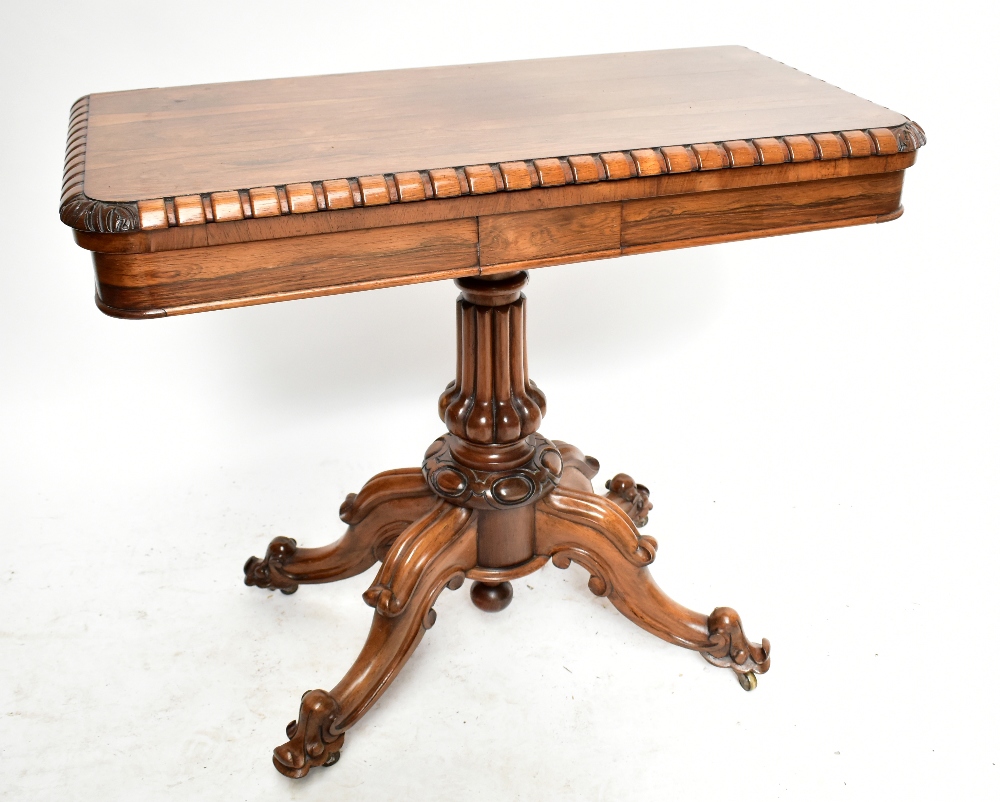 An early 19th century rosewood card table with carved detail on lobed column to four knee carved