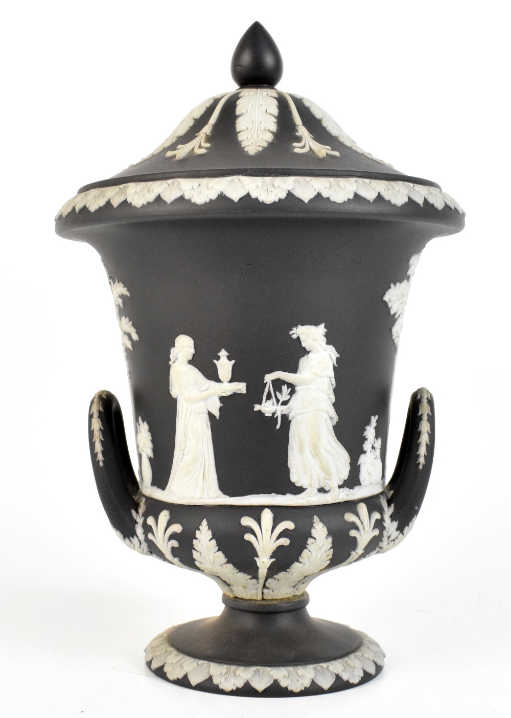 WEDGWOOD; a black and white jasper dip urn and cover relief decorated with Classical figures, with