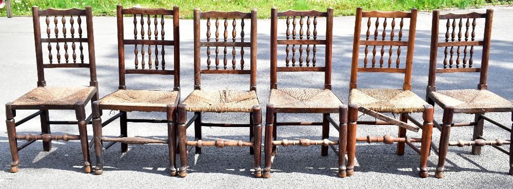 A harlequin set of six 19th century and later rush seated spindle back dining chairs, raised on