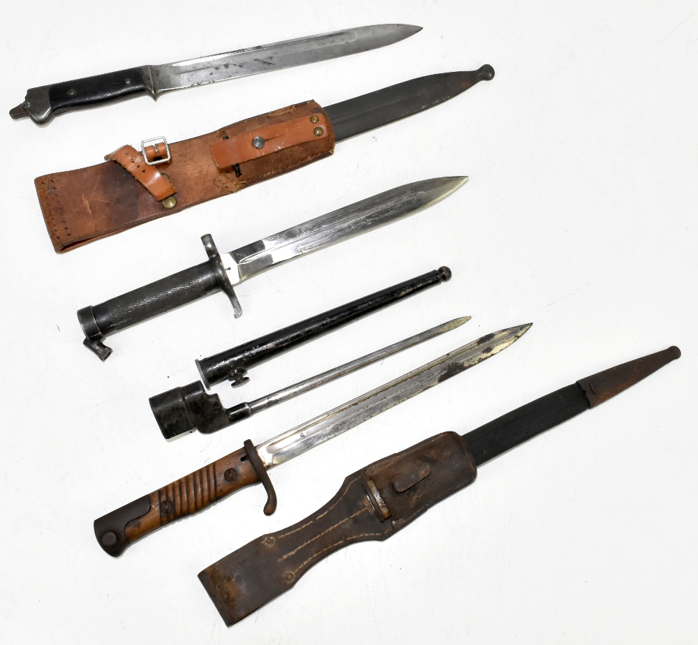 Four bayonets including two German and a socket example, two with scabbards and frogs, the two