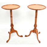 A pair of mid 20th century satinwood circular wine tables, the dished tops with carved pie crust