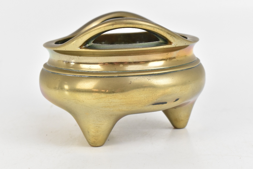 A Chinese bronze censer with pierced twin raised handles and three simple tapering supports, - Image 2 of 7