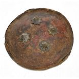 An Indian hide covered dahl shield with applied brass devices, for restoration, diameter 26.5cm.