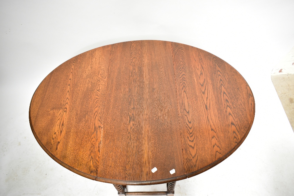 A 1920s oak dropleaf gateleg dining table, raised on barleytwist supports, height 73cm, length 88cm. - Image 4 of 4