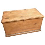 An old pine blanket chest of rectangular form, with black iron handles, raised on plinth base,