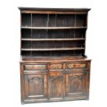 An 18th century Shropshire dresser, the boarded back section with three fixed shelves above the base